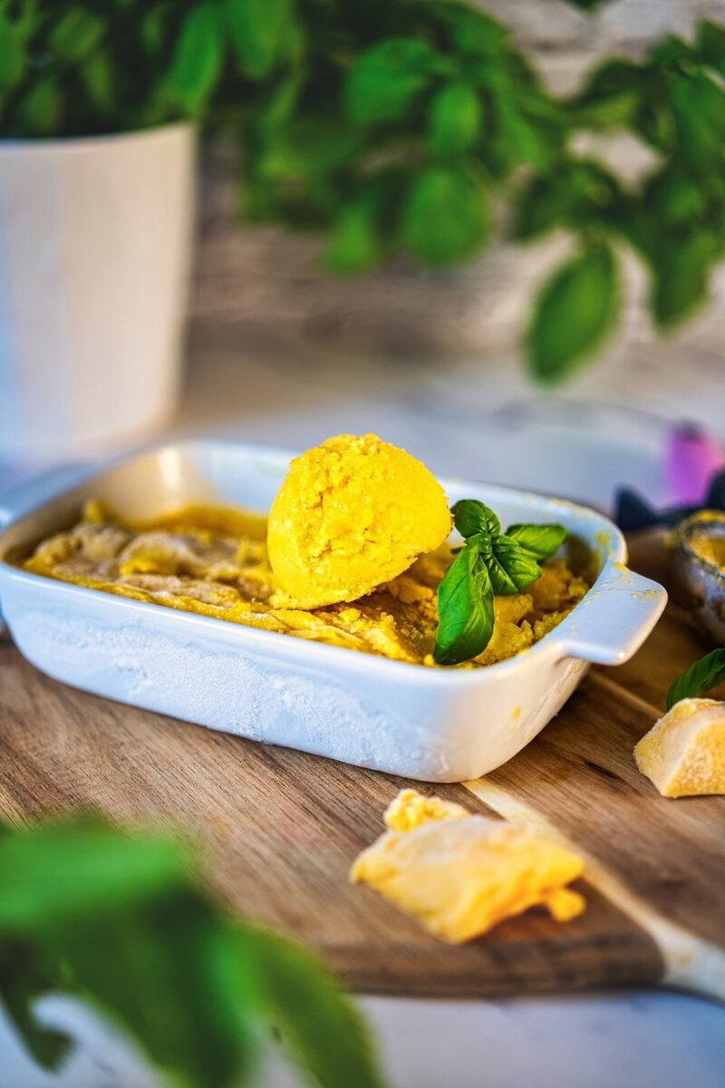 Close-up of mango sorbet scooped from a dish, showcasing simple 3 ingredient recipe with basil leaves