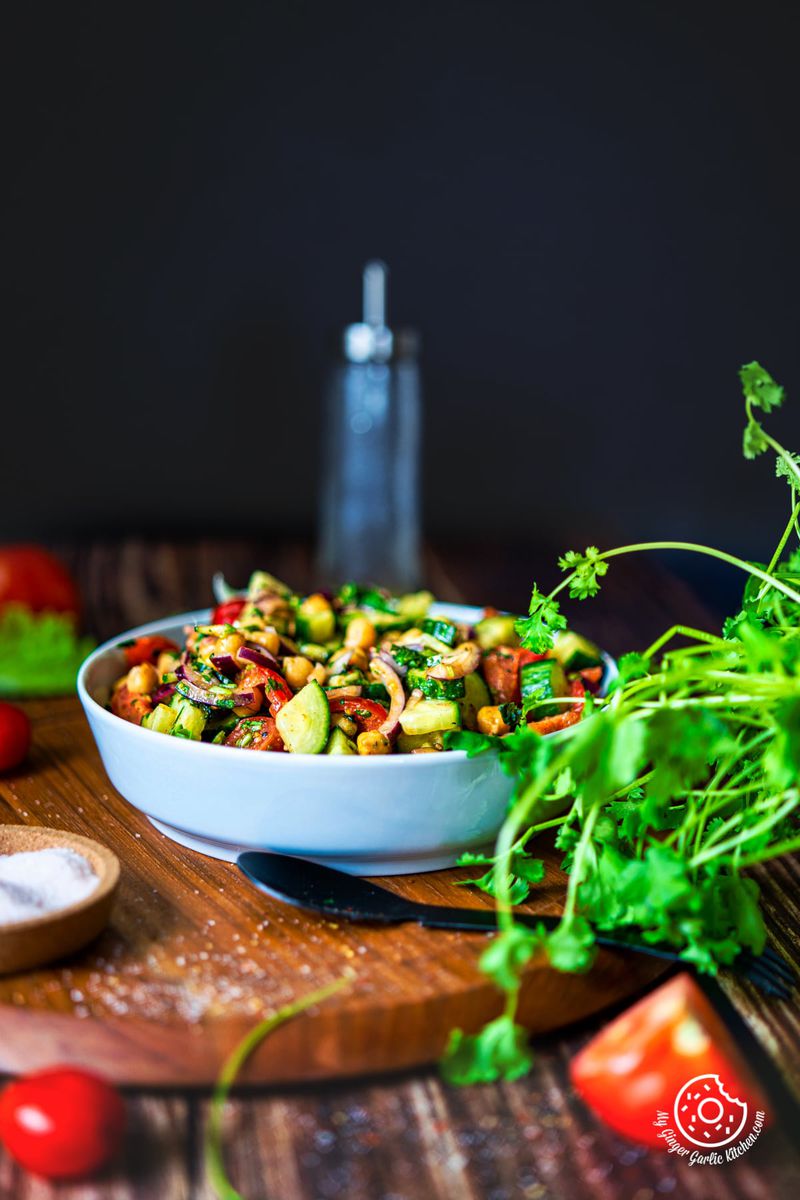 chickpea salad served in a light grey ceramic bowl with cilantro on the side