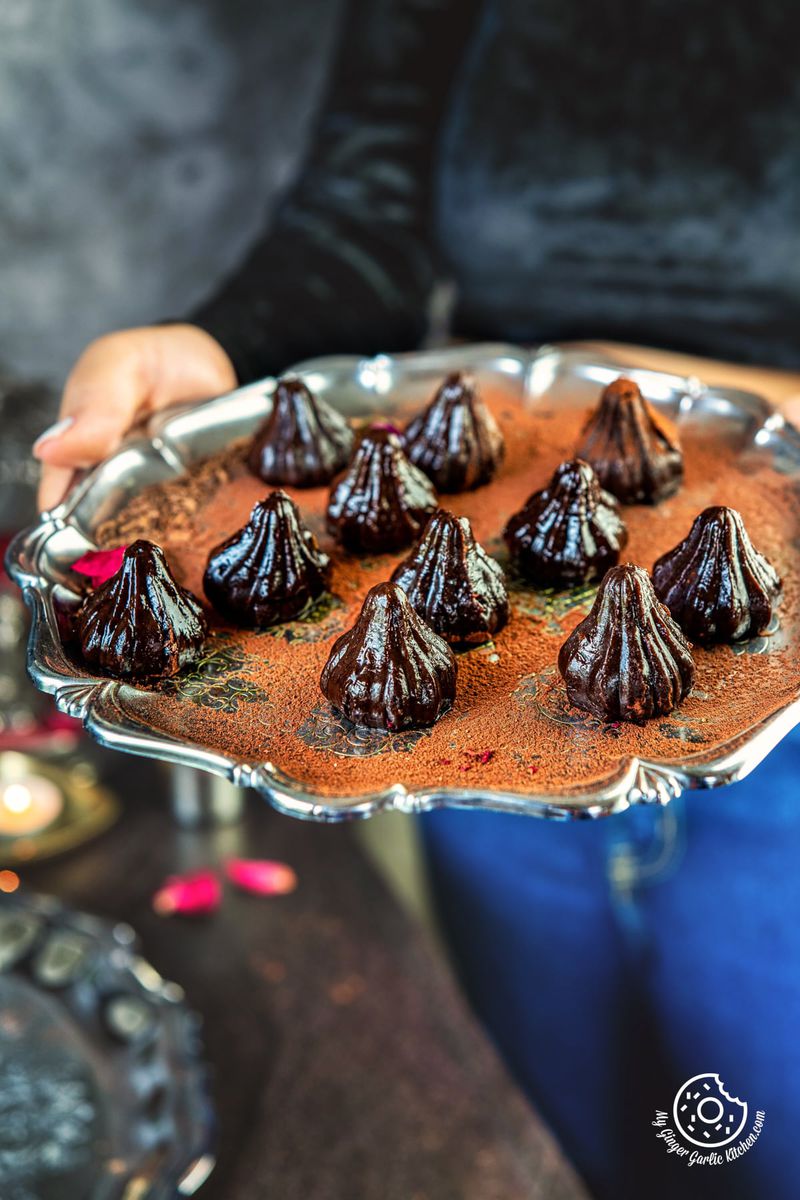 a female holding steel plate with 11 chocolate modaks