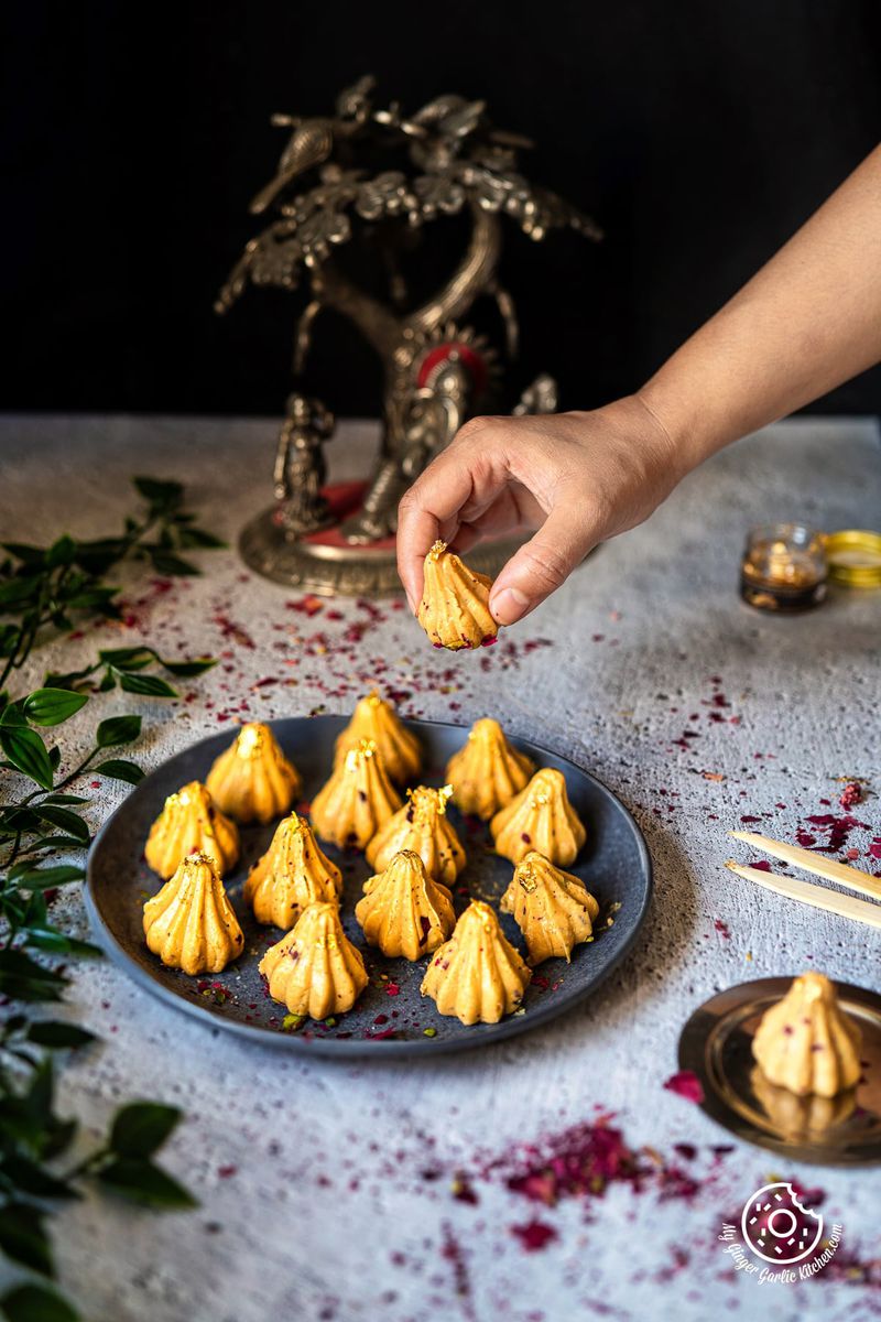 photo of a person placing a modak on a plate with Dulce De Leche Modaks