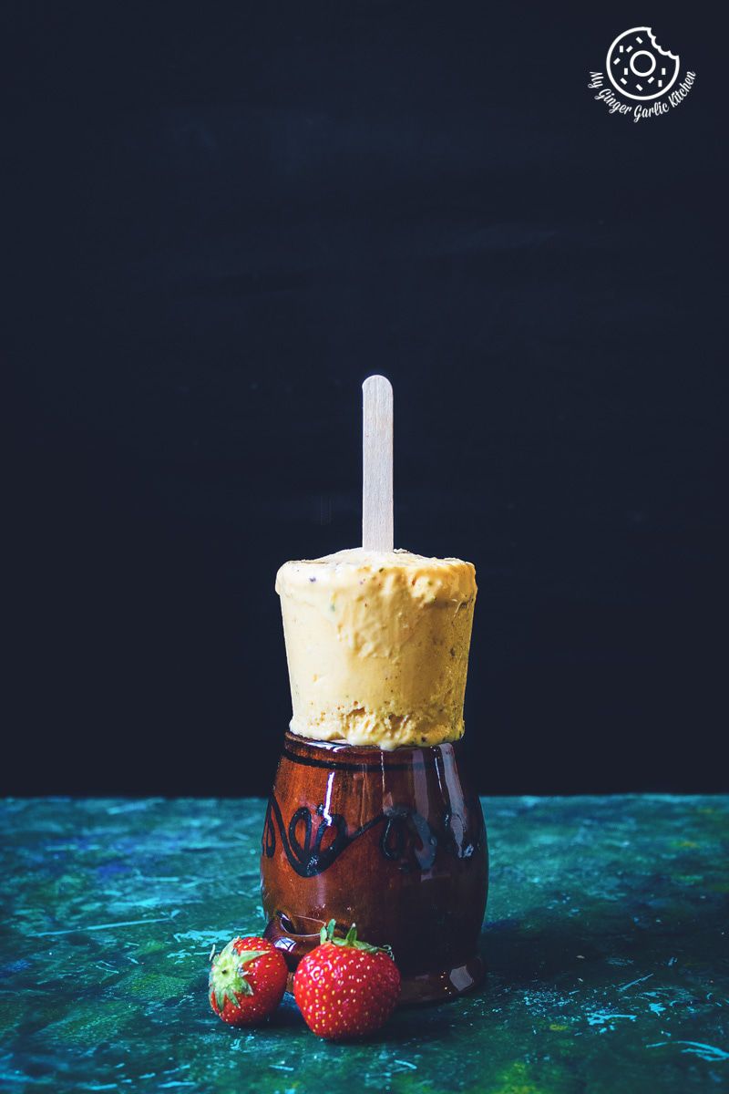 a mango kulfi with a strawberries on top of it