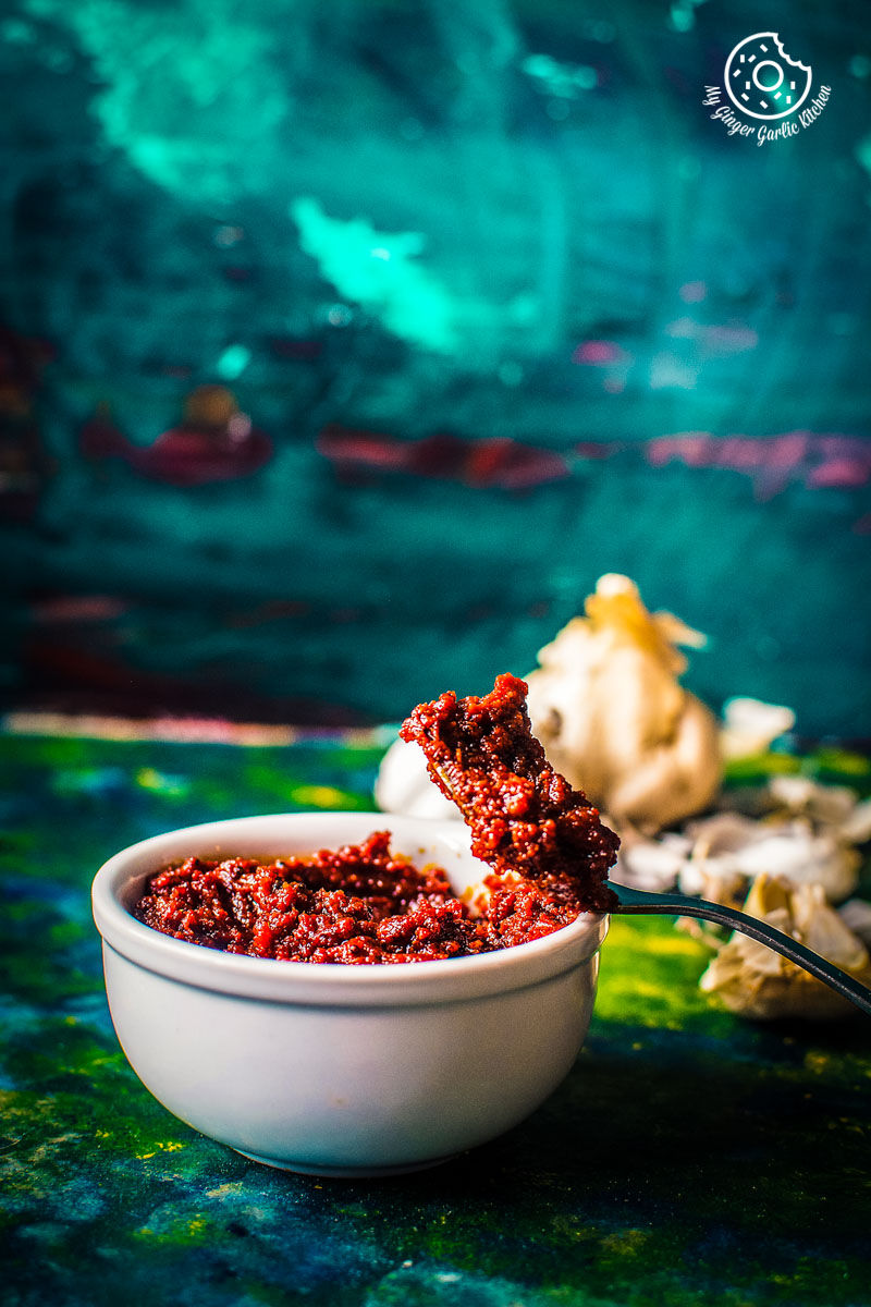there is a bowl of rajasthani lehsun ki chutney with a spoon in it