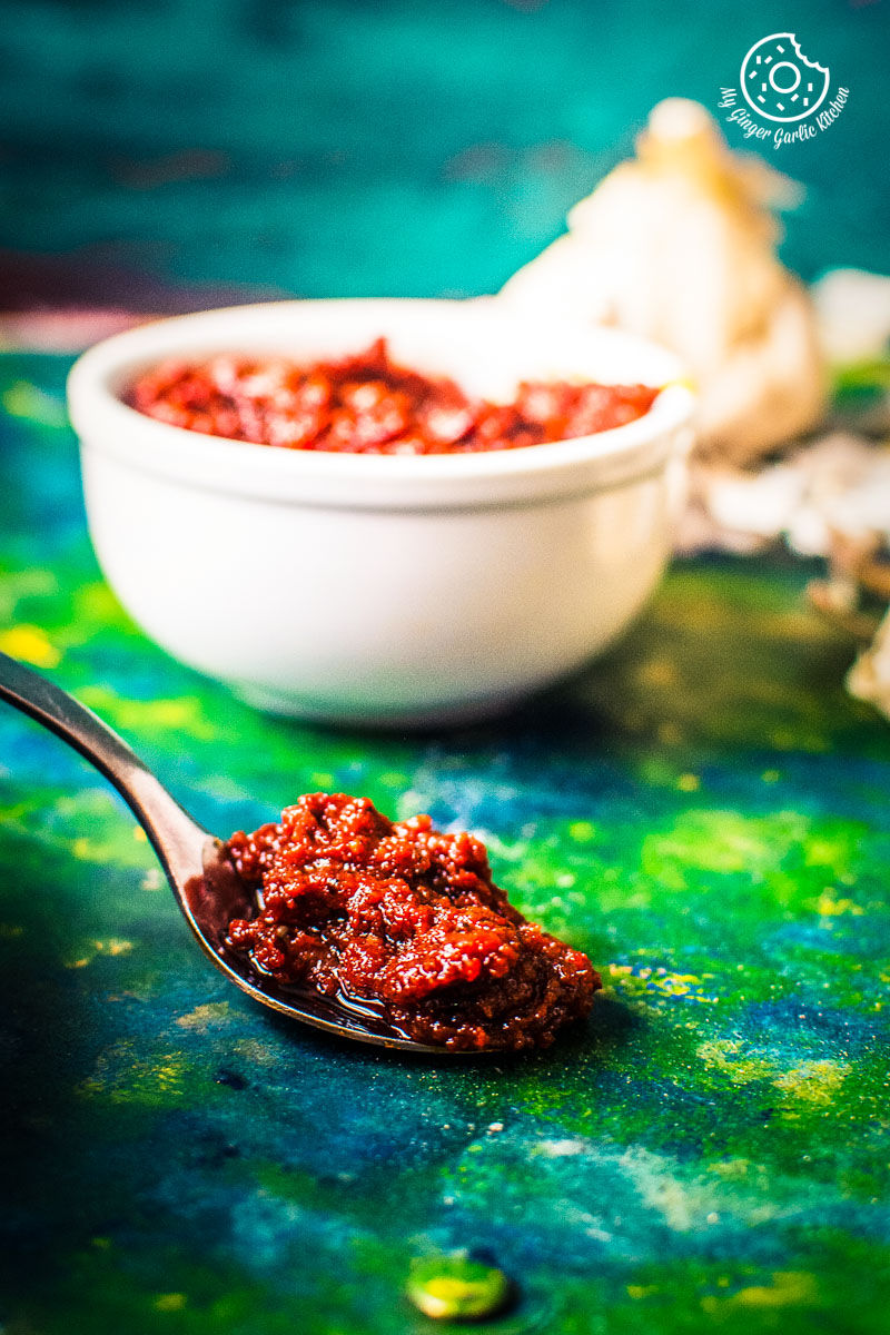 there is a spoon with a spoonful of rajasthani lehsun ki chutney on it