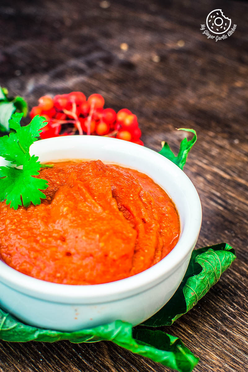 there is a bowl of rajasthani lehsun ki chutney with a garnish on top