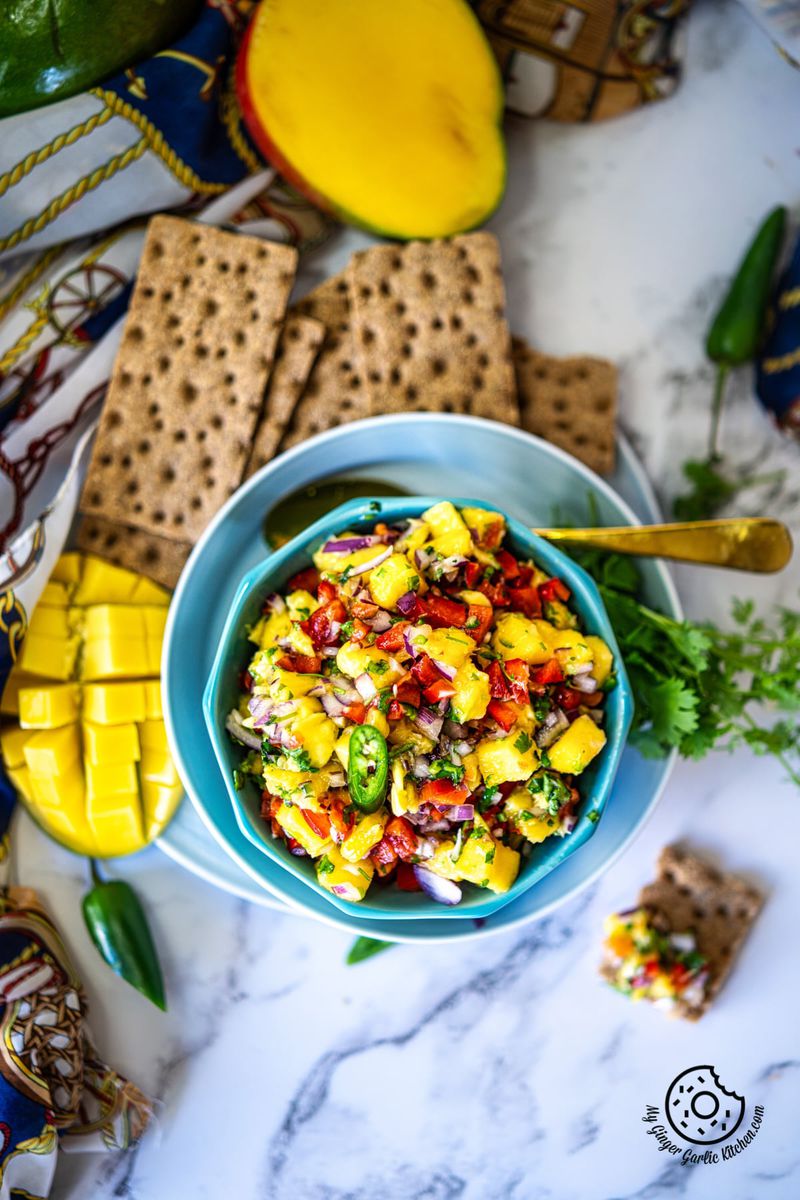 overhead shot of a mango salsa bowl and a mango slice on the side