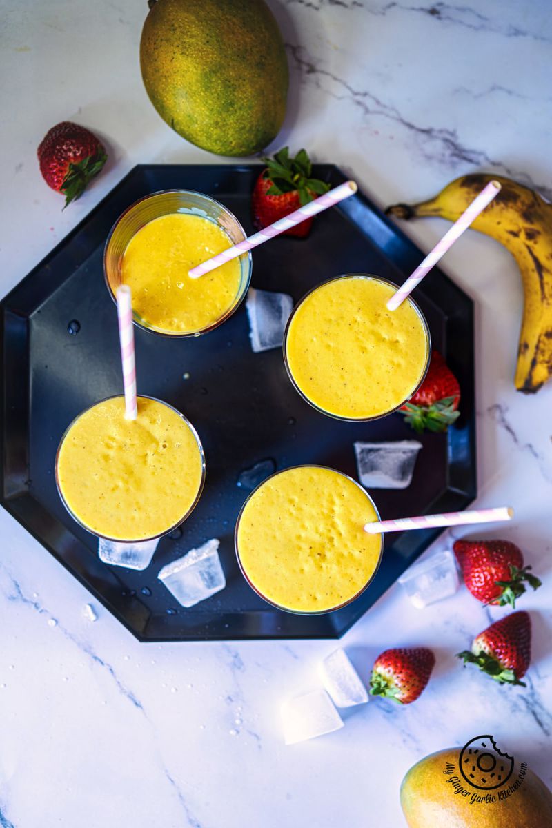 overhead shot of four mango smoothie glasses