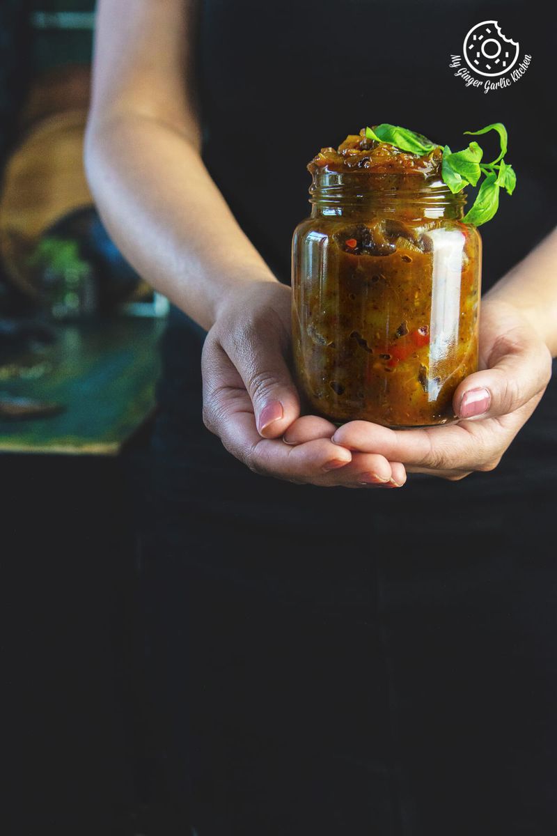 a female is holding peach chutney jar