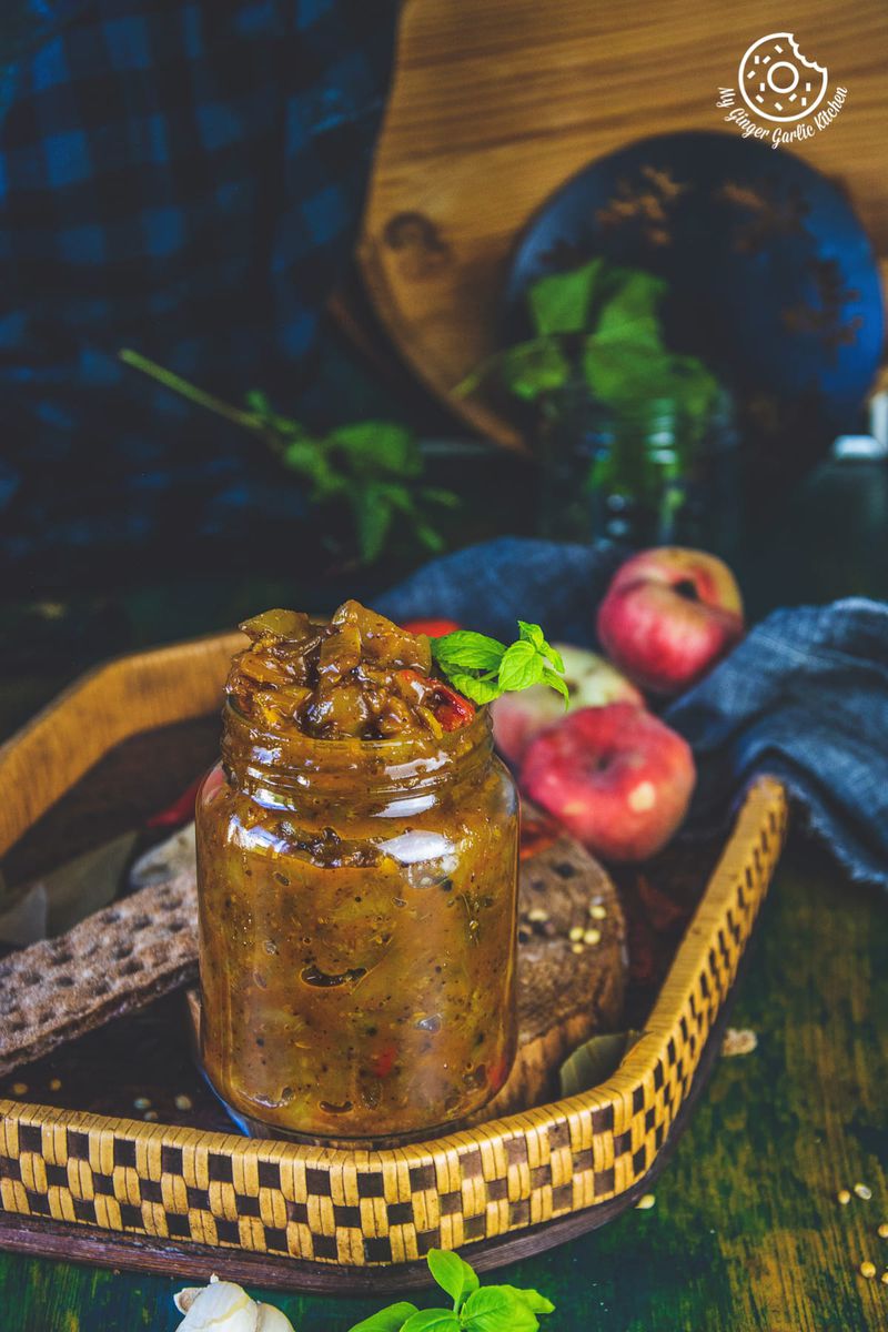 peach chutney jar in a wooden tray and some peaches in background
