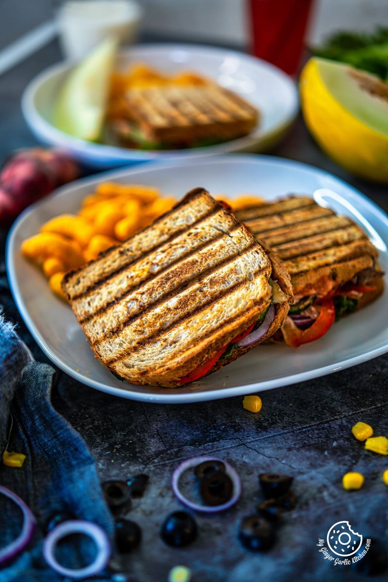 peanut butter and veggie grilled cheese sandwiches in a white plate along with cheese puffs