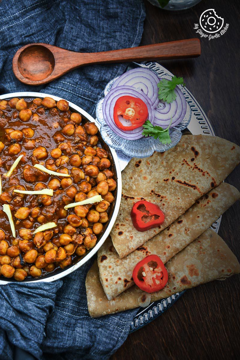 a bowl of amritsari chole and parathas on a table
