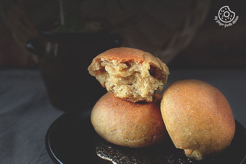 two full and one half eaten bati on a plate