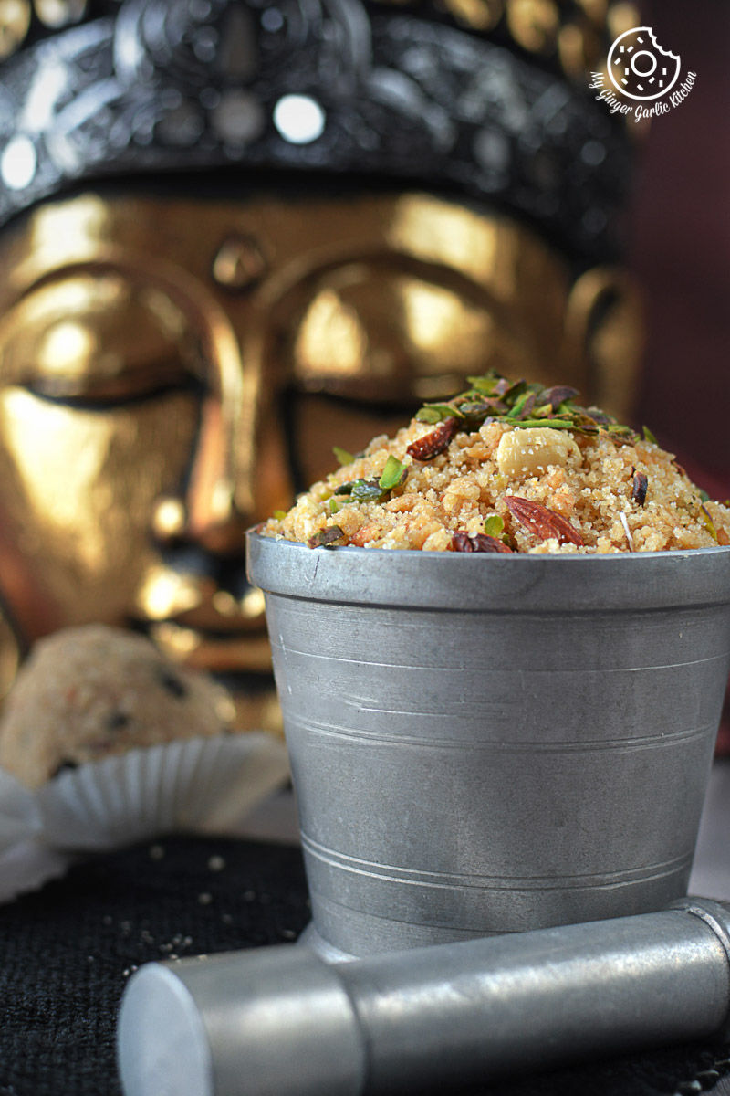 a silver mortar filled with churma next to a statue