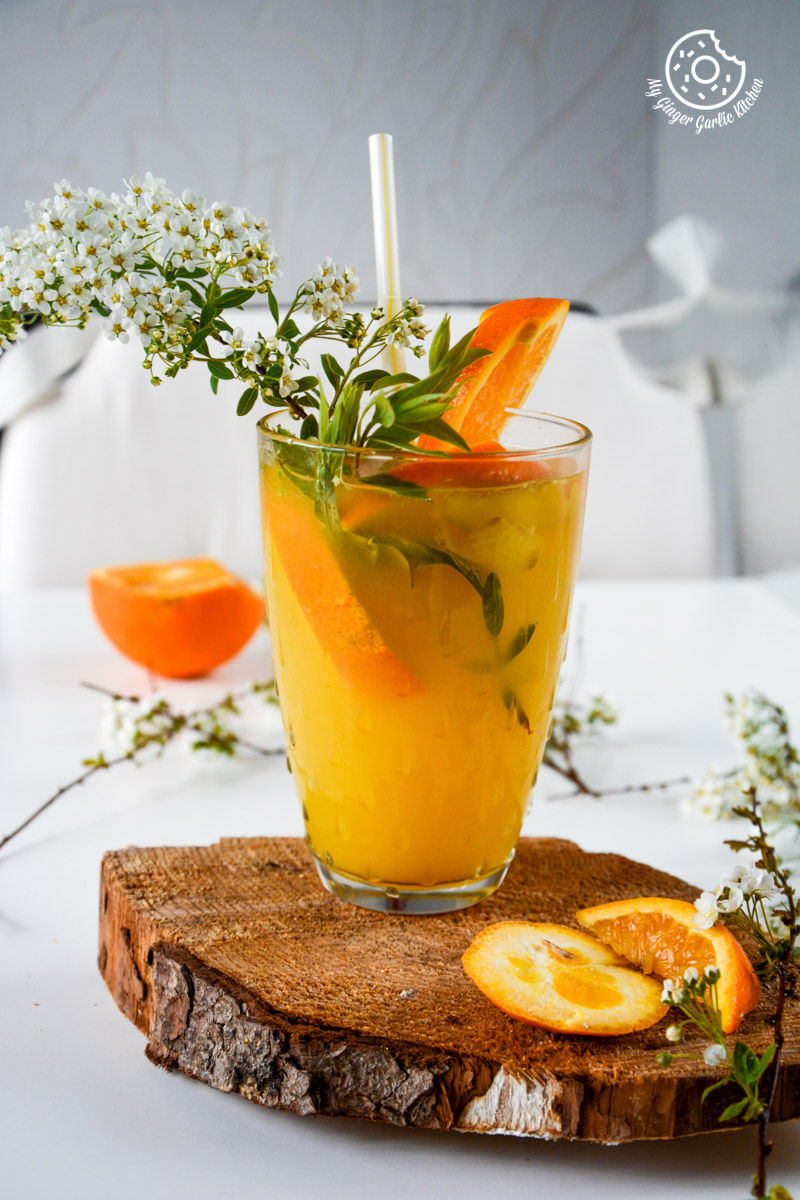 a glass of virgin ginger mimosa with a straw and a flower