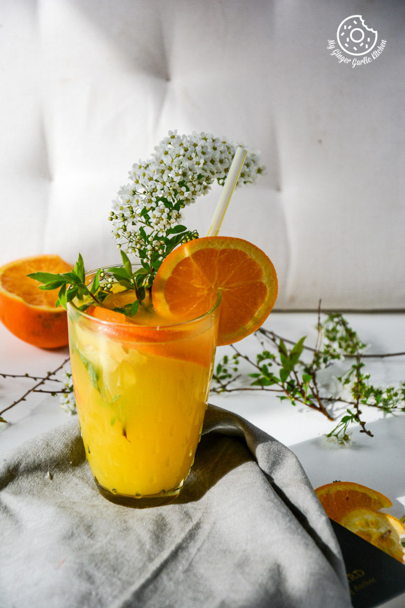 a glass of virgin ginger mimosa with a straw and a flower