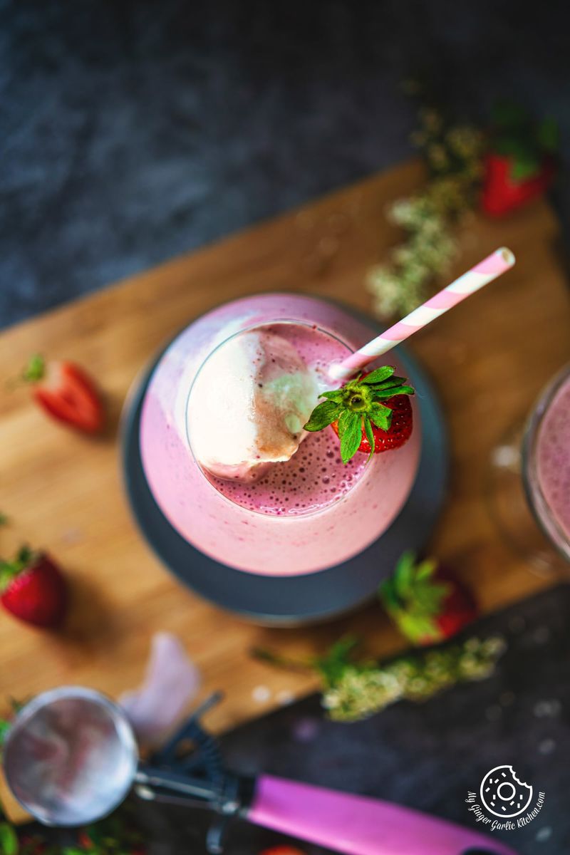 overhead shot of strawberry milkshake topped with ice cream and strawberry