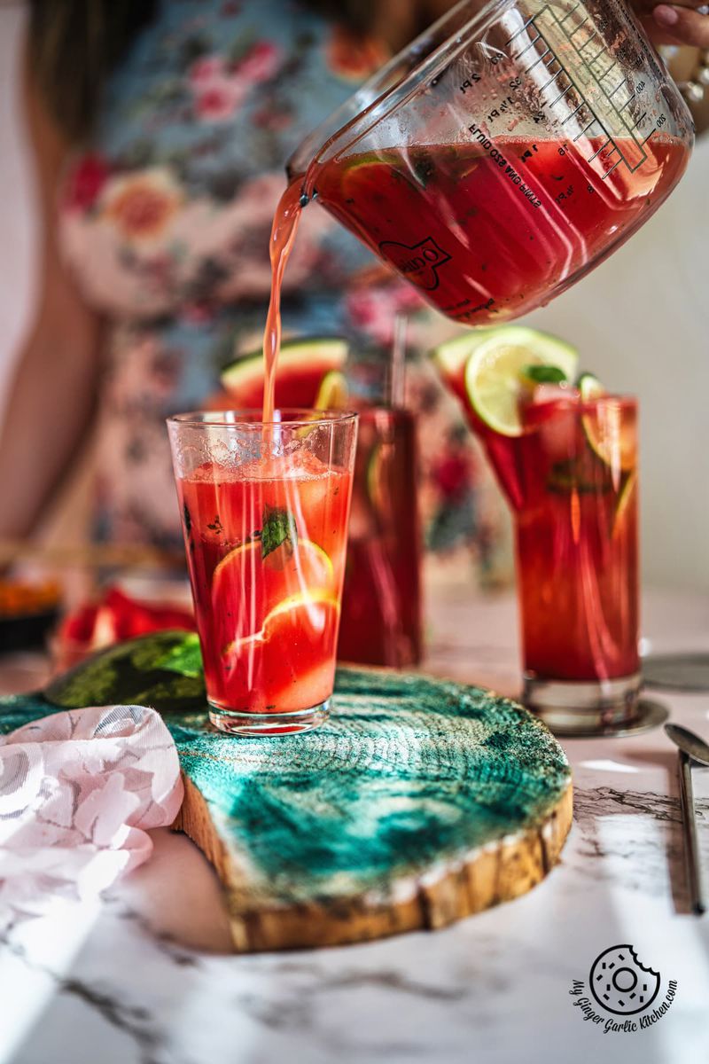 a female pouring watermelon mojito in a glass